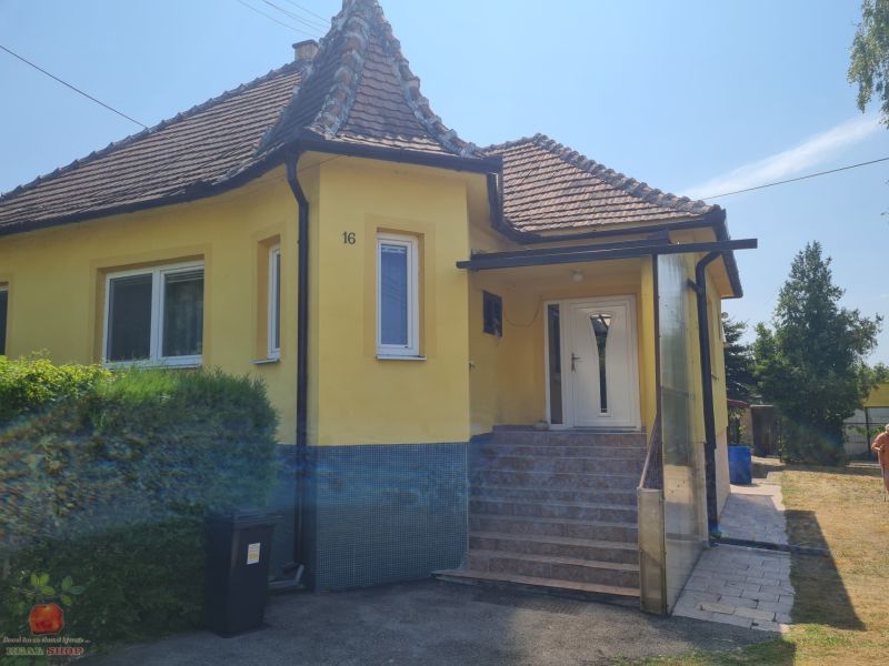 A family house in Komjatice with a sloped roof and yellow facade.