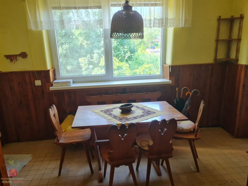 Dining area in a family house with wooden paneling and a classic table.