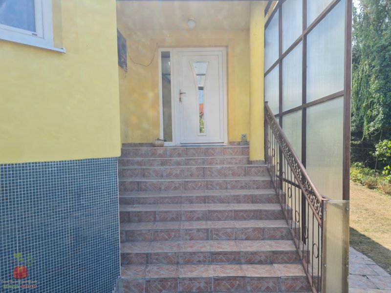 The entrance of the family house with stairs is surrounded by a garden in Komjatice.