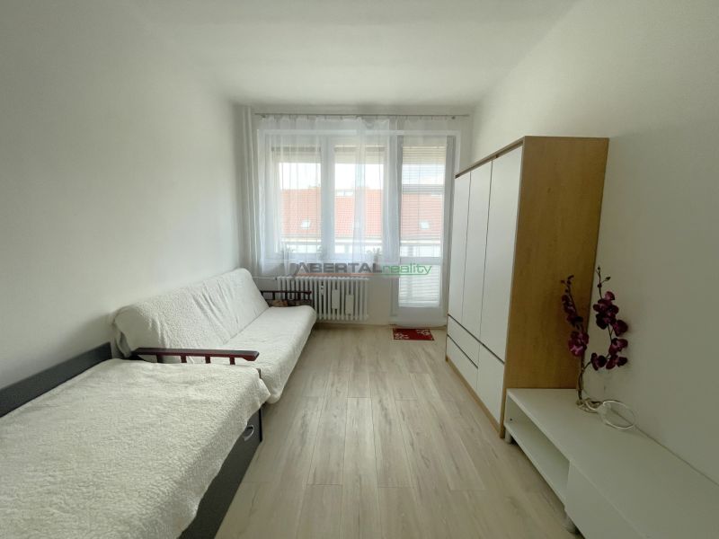Living room in a 3-room apartment with light walls and a floor with a wood decor.