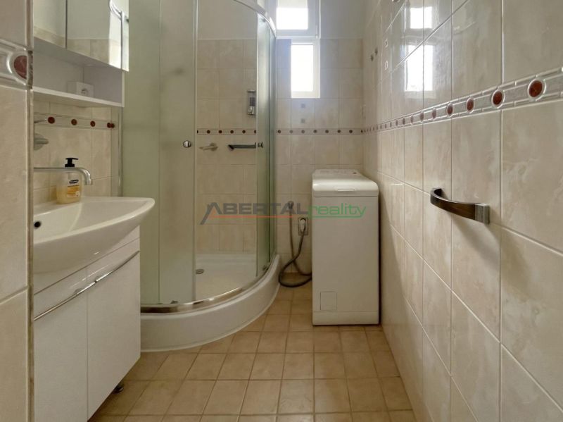 Bathroom with a sink, shower, and washing machine in a 3-room apartment.
