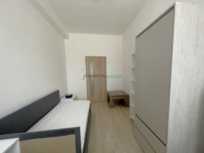 Bedroom in a 3-room apartment with a bed, wardrobe, and floor with a wooden decor.