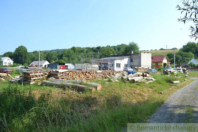 Family houses in Varadka with cut wood in the yard, rural environment.