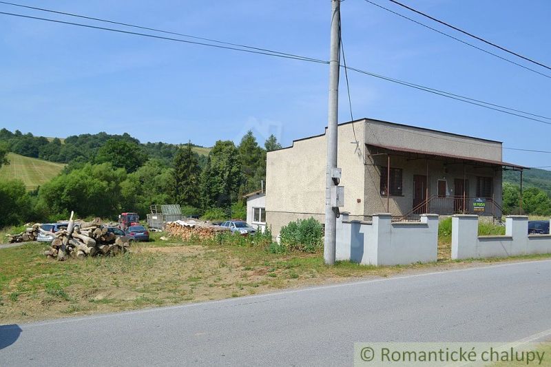 A family house in Varadka, by the main road, with wood and cars on the property.