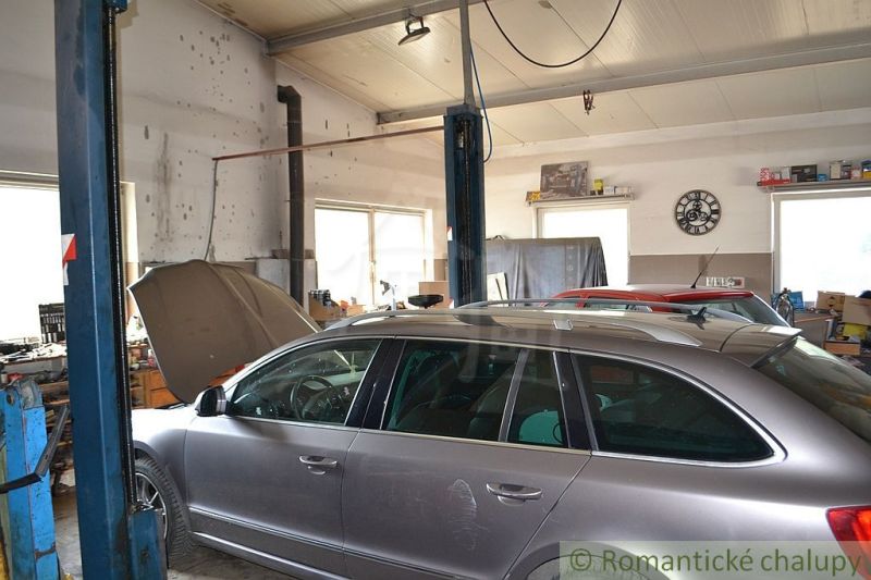 A car service in a family house with two vehicles being prepared for repair.