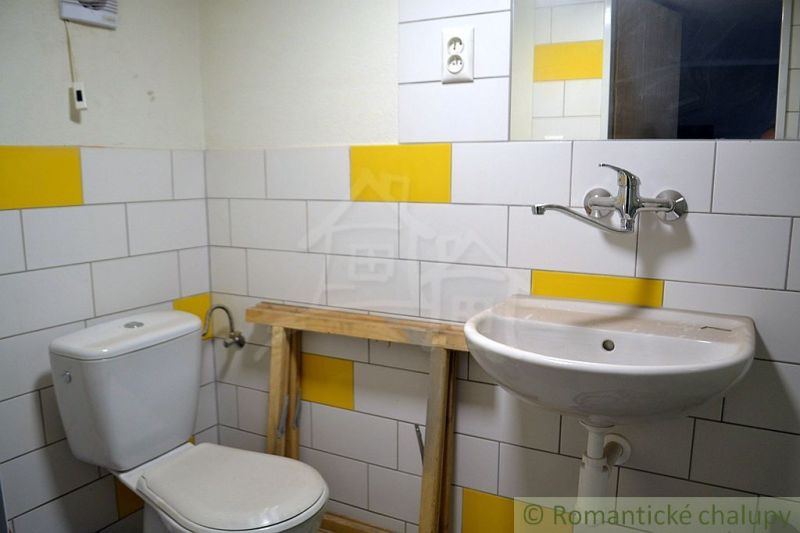 A bathroom in a family house with tiles in white and yellow color.