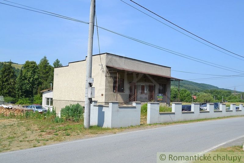 A family house in Varadka with fencing by the road and surroundings with forests.