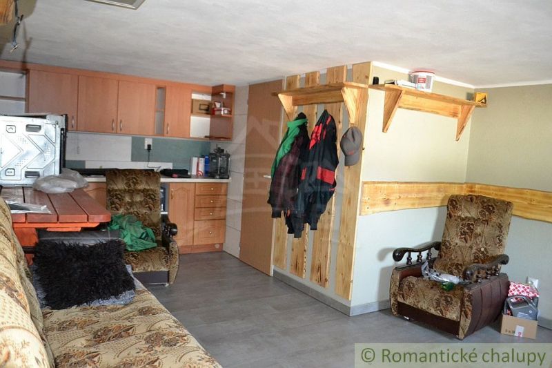A kitchen in a family house with wooden decor, a sofa, and a dining area.
