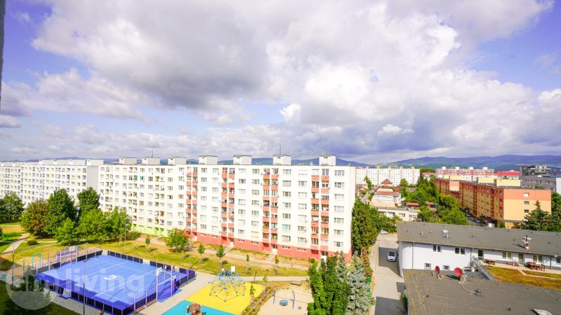 View from Pod Hájom Street in Dubnica nad Váhom towards apartment buildings and a sports facility.