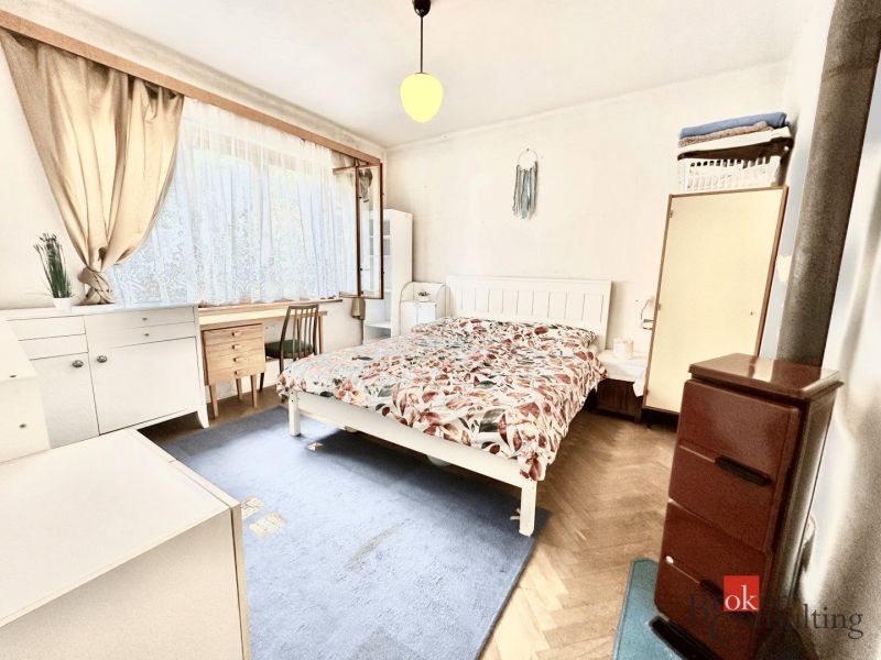 Bedroom in a family house with a bed, carpet, and desk.