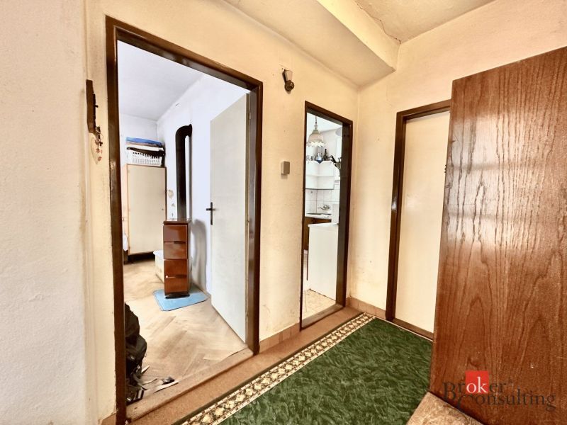 Interior of a family house with a corridor, doors, and flooring with a wooden decor.