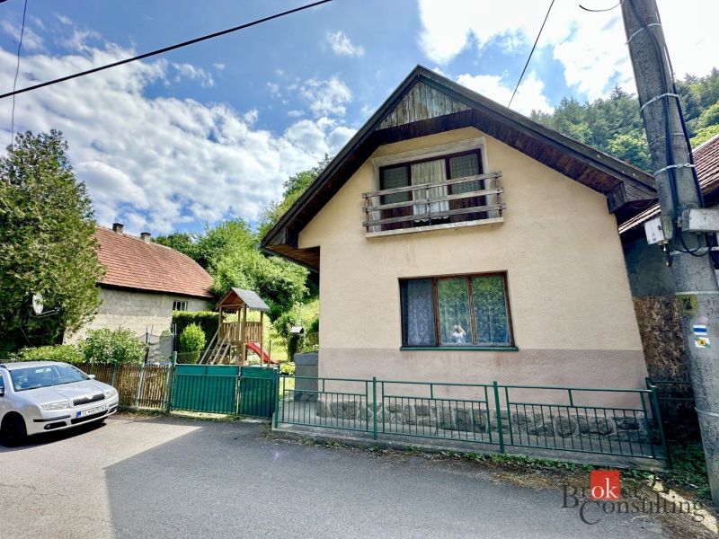 A family house in Žiar nad Hronom with a wooden balcony and a garden with climbing frames.