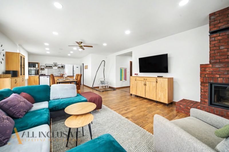 Living room in a family house with a wood-patterned floor and a fireplace.