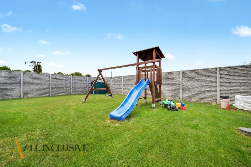 A children's playground with a swing and a slide in a family house in Vozokany.