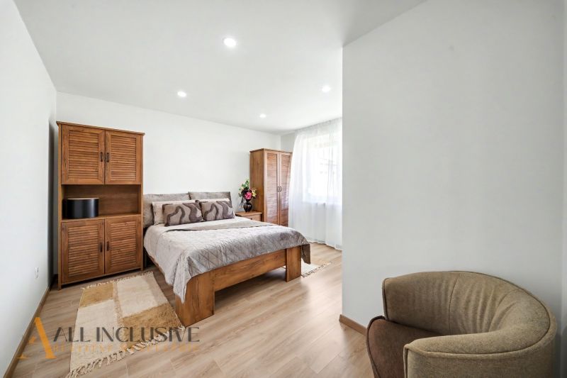 A bedroom in a family house with wooden furniture and a wood-patterned floor.
