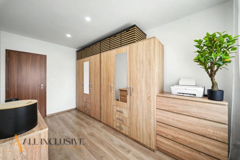 Interior design of a family house with wooden decor and a plant on the cabinet.
