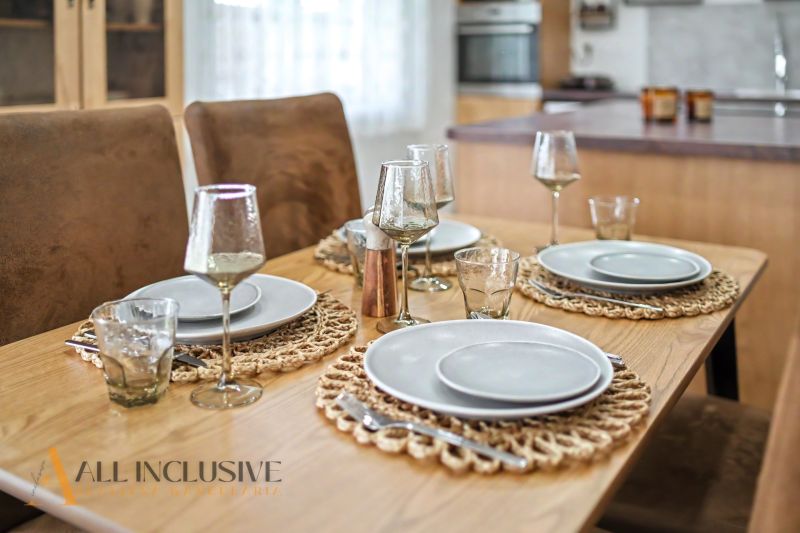 Dining table with plates, glasses, cutlery in a family house.