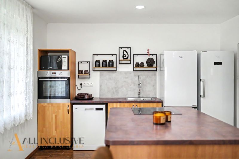 A stylish kitchen with white appliances, cooking, and shelves in a family house.