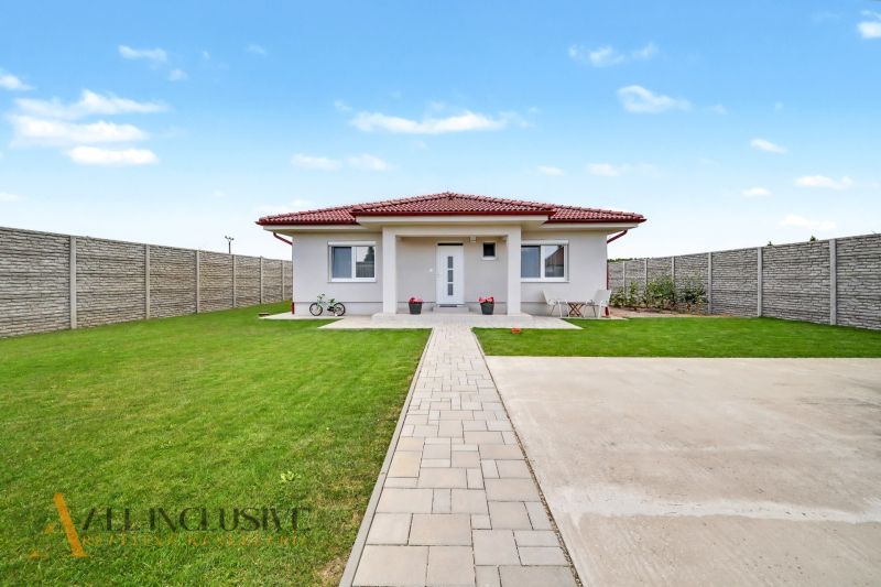 A family house in Vozokany with a lawn, terrace, and a bicycle in front of the entrance.
