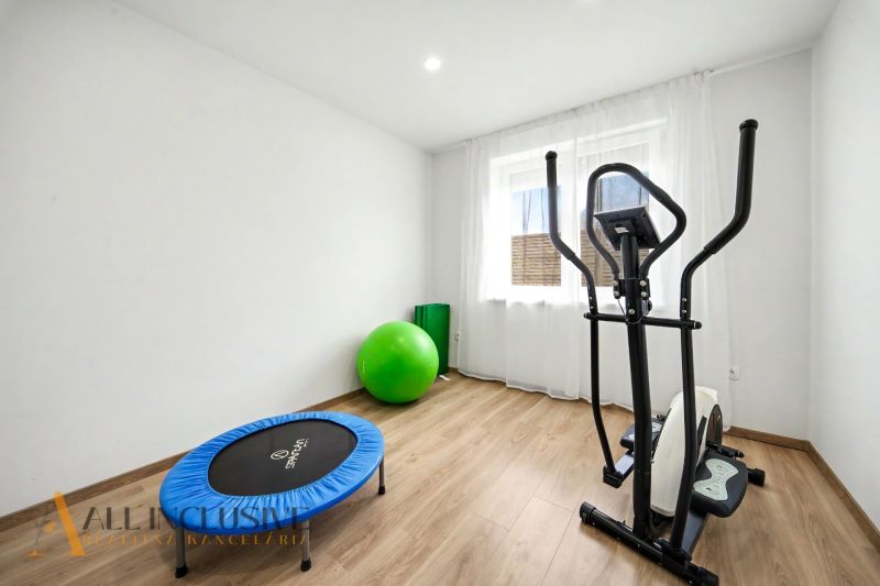 Family house with an exercise room, cardio trainer, and flooring with a wooden design.