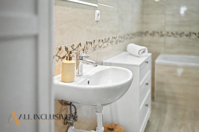 Bathroom in a family house with a sink and decorative tiles.