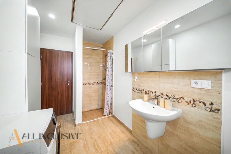 Bathroom in a family house with a sink, shower, and mirror cabinet.