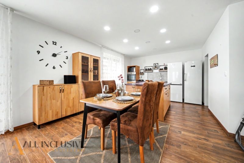 Dining room in a family house with a table, chairs, and a floor with a wooden decor.