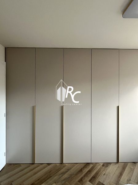 Built-in wardrobe with wood-decor flooring in a 2-room apartment.
