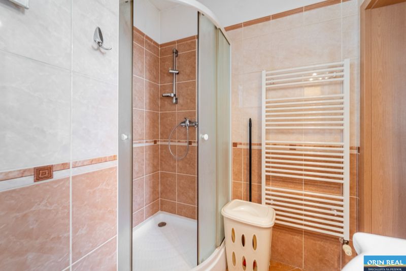 Bathroom with a shower and a towel rack in a studio apartment.
