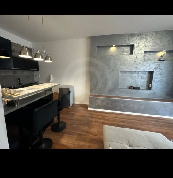 A kitchen corner with a bar counter and a floor with a wood decor in a 2-room apartment.