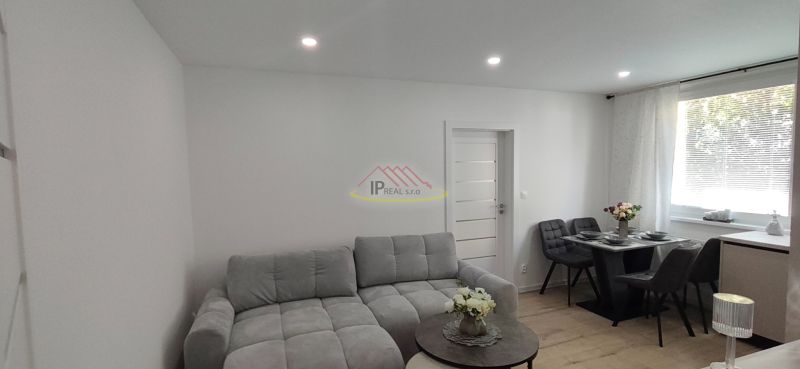 A bright living room in a 3-room apartment with a sofa and a dining table.