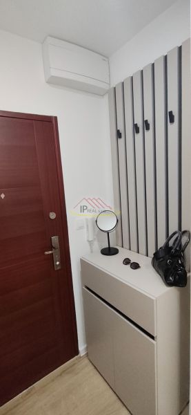 Entrance hallway with a coat rack in a 3-room apartment with a wooden decor floor.