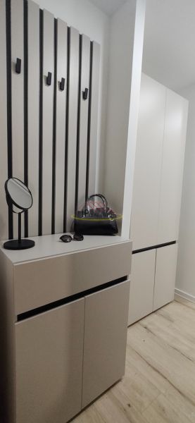 In the 3-room apartment, there is an entrance hall with coat hooks, a wardrobe, and a floor with a wooden decor.