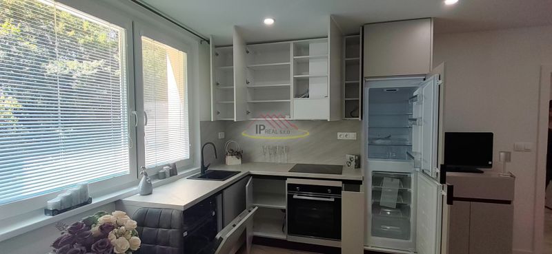 A kitchen in a 3-room apartment with a marble countertop and built-in appliances.