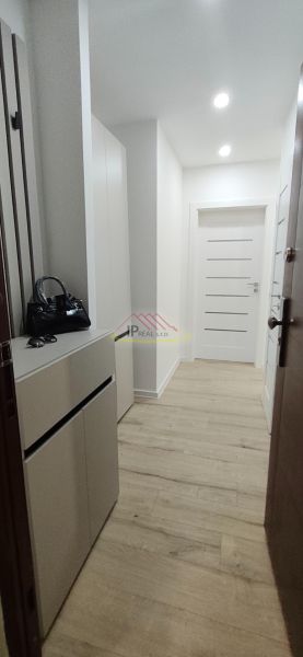 A bright hallway with furniture and doors, a floor with a wooden decor, a 3-room apartment.