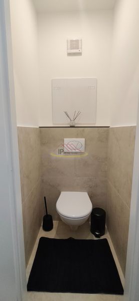 A toilet with tiling and decoration in a 3-room apartment.