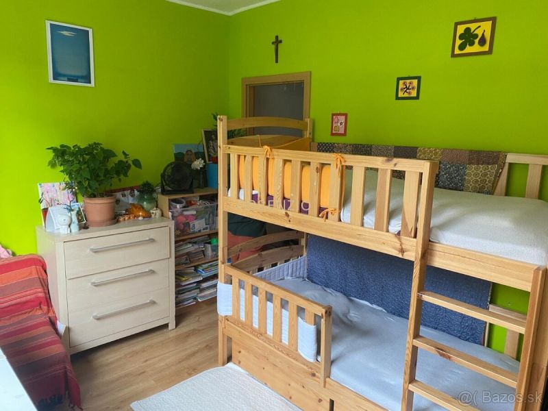 Children's room with a bunk bed, wooden decor flooring, and bright green walls.