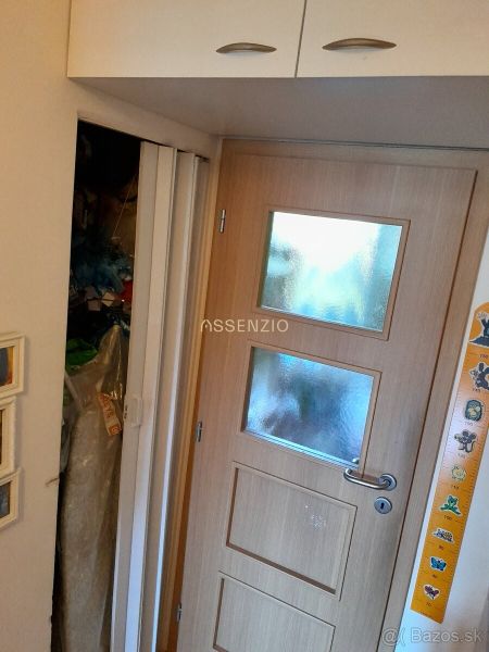 Interior of a 2-room apartment with wooden entrance doors and a built-in wardrobe.