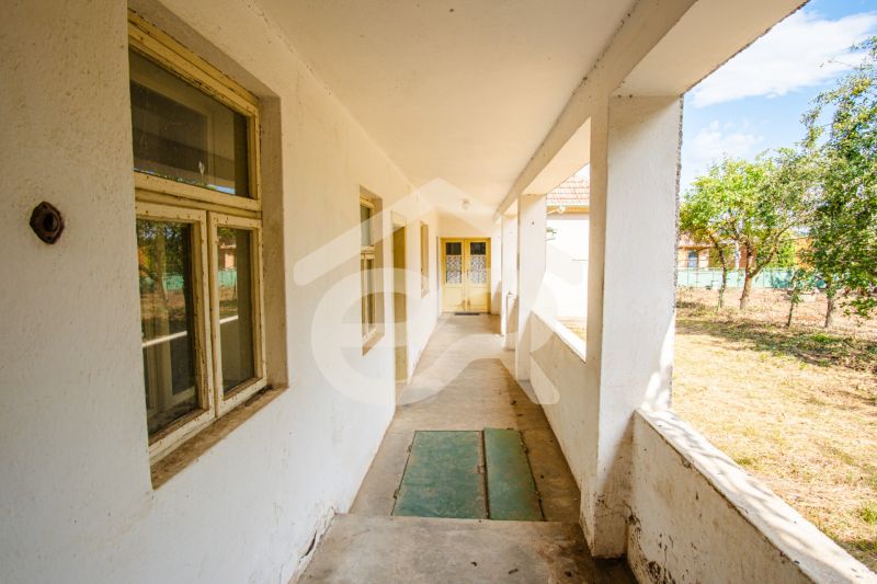 The exterior of a family house in Kapince with older windows and a veranda.