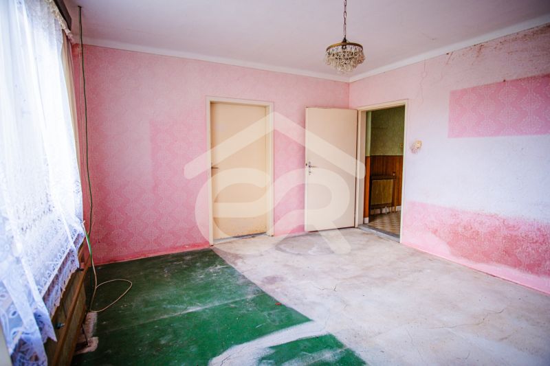 A room in a family house with pink walls and floral patterned curtains.