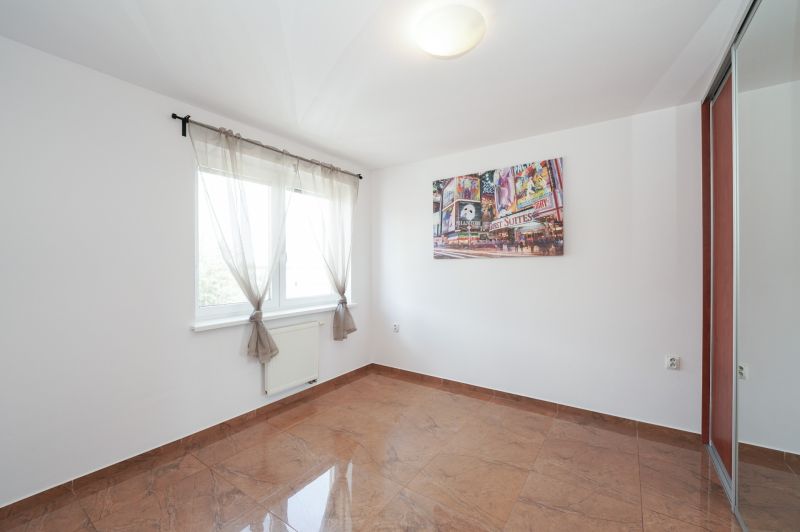 A bright room with a large window, built-in wardrobe, and tiles in a 3-room apartment.