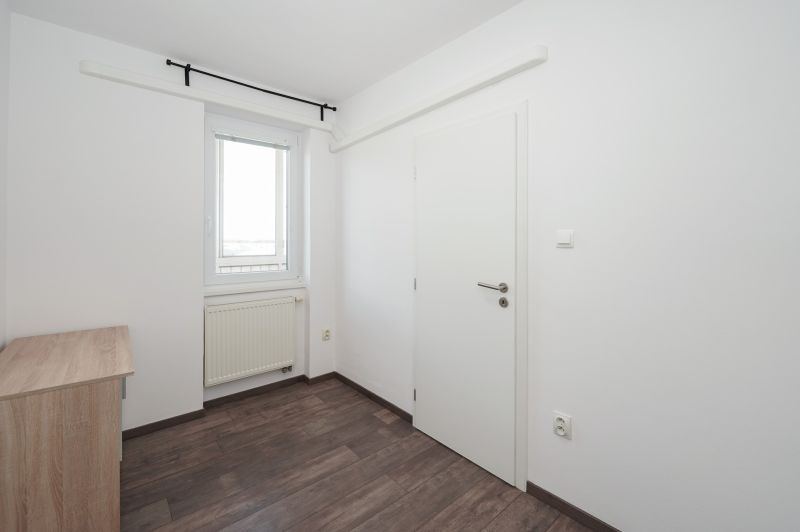 A bright room in a 3-room apartment with a wooden decor floor.