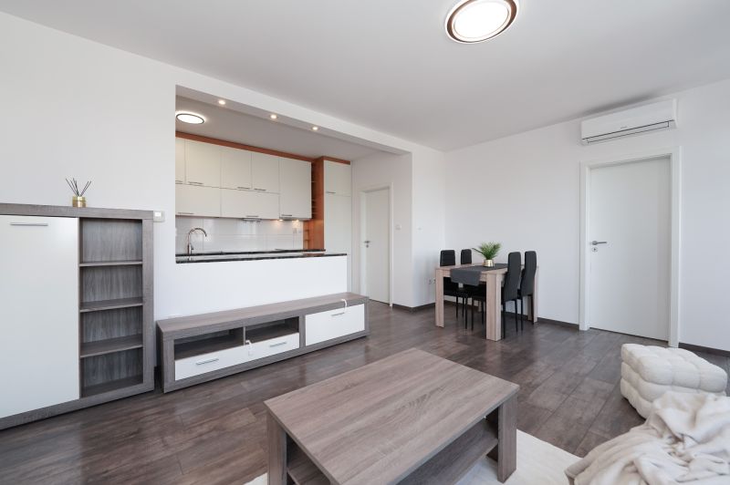 Living room in a 3-room apartment with a kitchen, floor with wood decor.