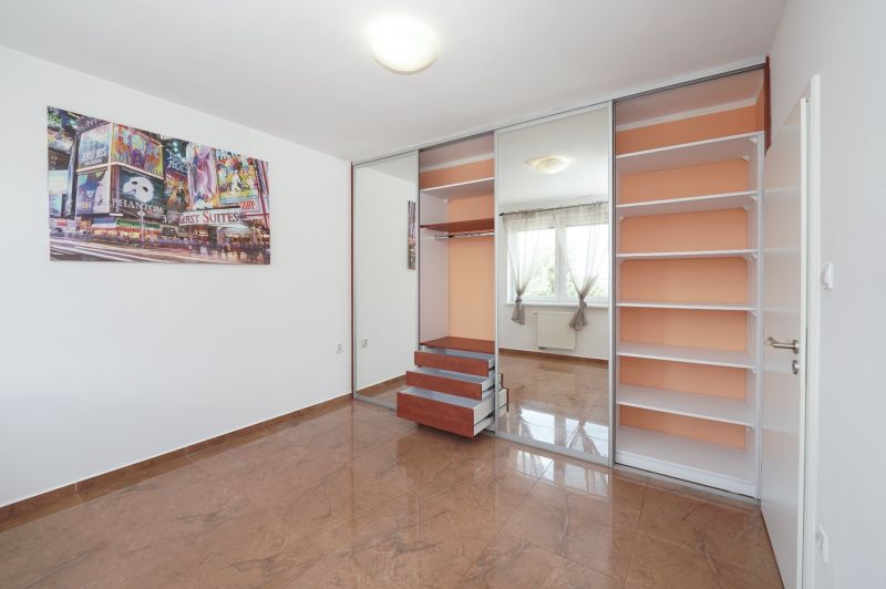A bright room with a large built-in wardrobe and decorative flooring in a 3-room apartment.