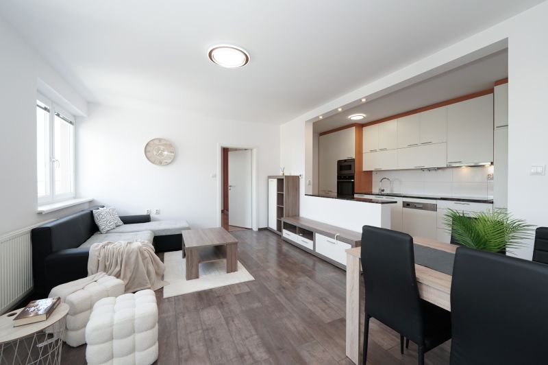 Living room with kitchen in a 3-room apartment with a wooden decor floor.