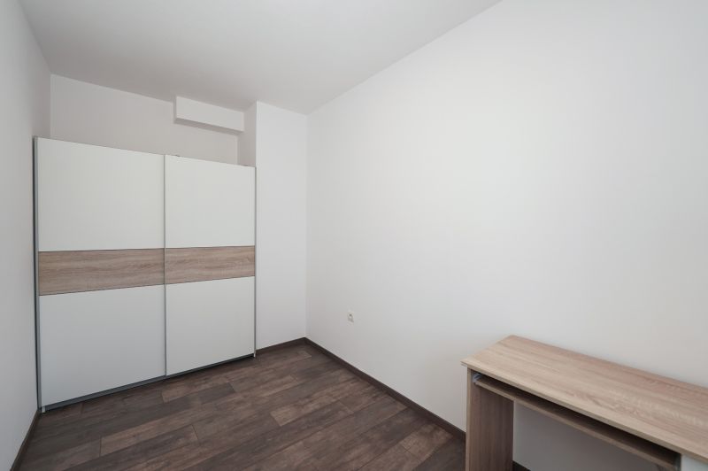 A room with a white wardrobe and a wooden decor floor in a 3-room apartment.