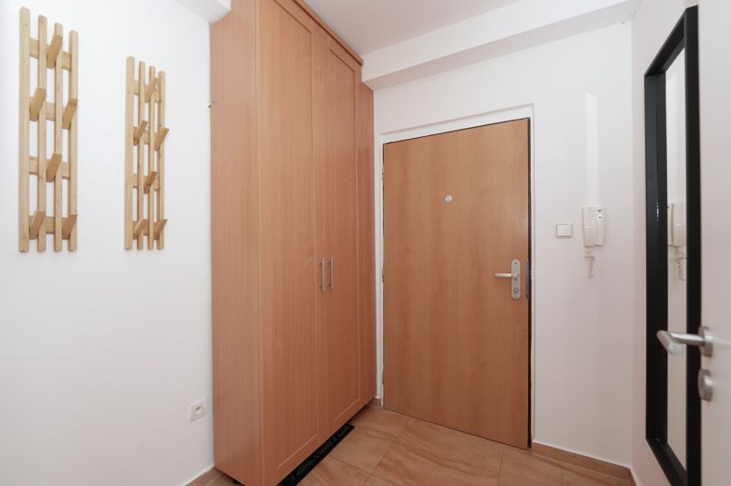 Entrance hall in a 3-room apartment with storage space and coat hooks, floor with wooden decor.