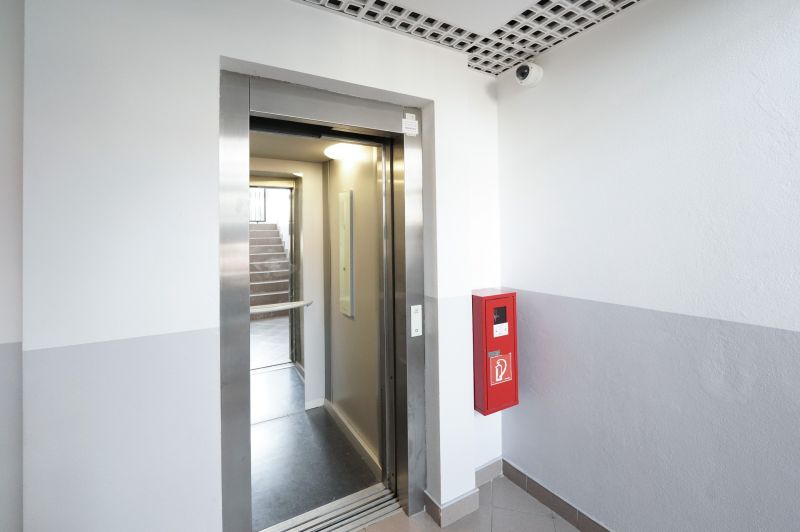 Elevator, staircase, red fire extinguisher in the interior, entrance to a 3-room apartment.