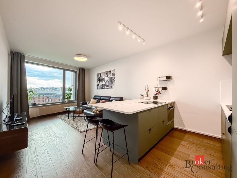 Living room in a two-room apartment with a wooden decor floor and a view of the city.