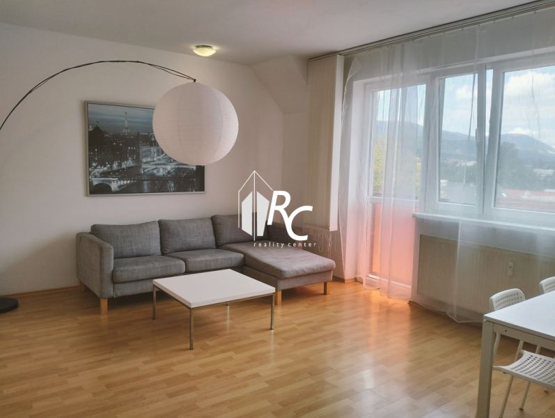 Bright living room in a 2-room apartment, sofa, table, wooden decor flooring.